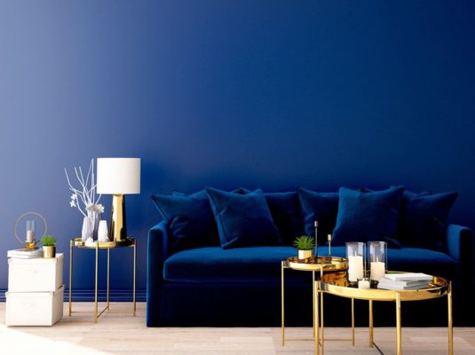 sofa azul classic blue con mesa centro dorado y pared azul